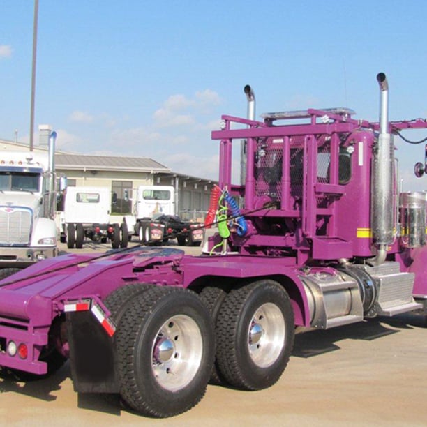 Back view of purple roll off truck