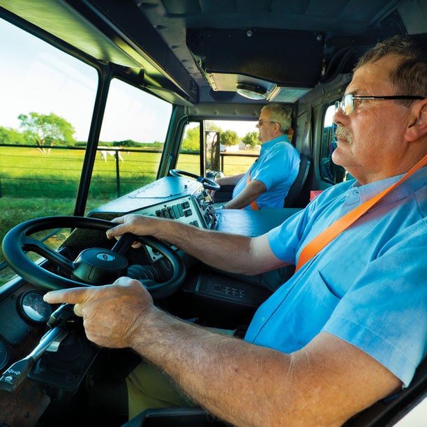 Two drivers driving truck with dual steering wheels